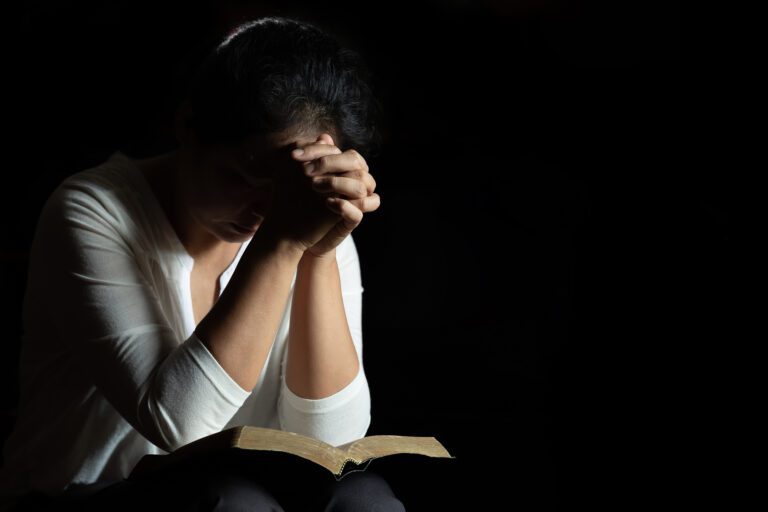 Spirituality and religion, Hands folded in prayer on a Holy Bibl