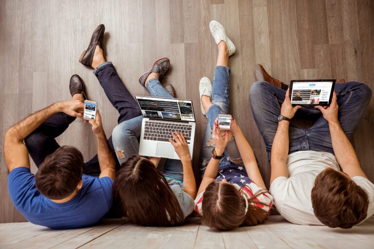 Group,Of,Attractive,Young,People,Sitting,On,The,Floor,Using